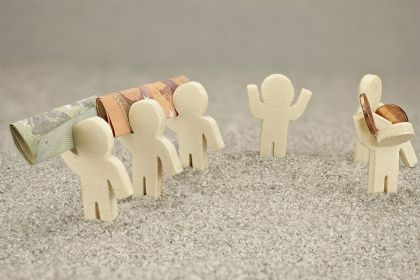 Foto: Kleine Figuren mit Geldscheinen und Münzen