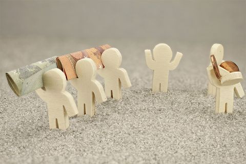 Foto: Kleine Figuren mit Geldscheinen und Münzen